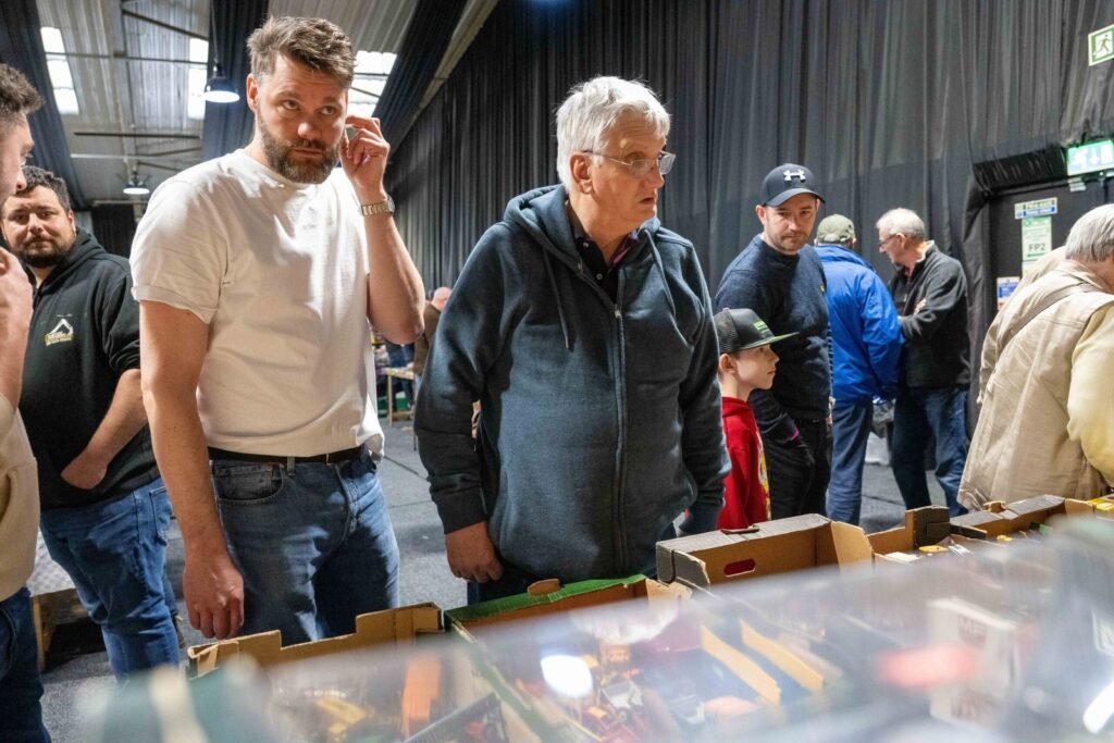 Visitors inspecting model tractors in a display case at the Spalding Model Tractor Show