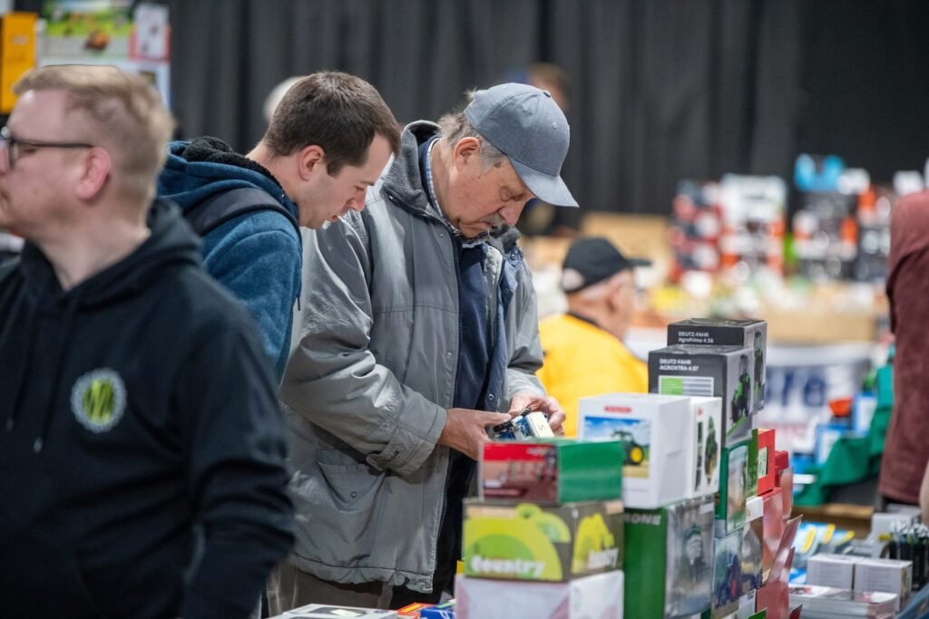 Collectors examining boxed model tractors on a trader's table at the Spalding Model Tractor Show