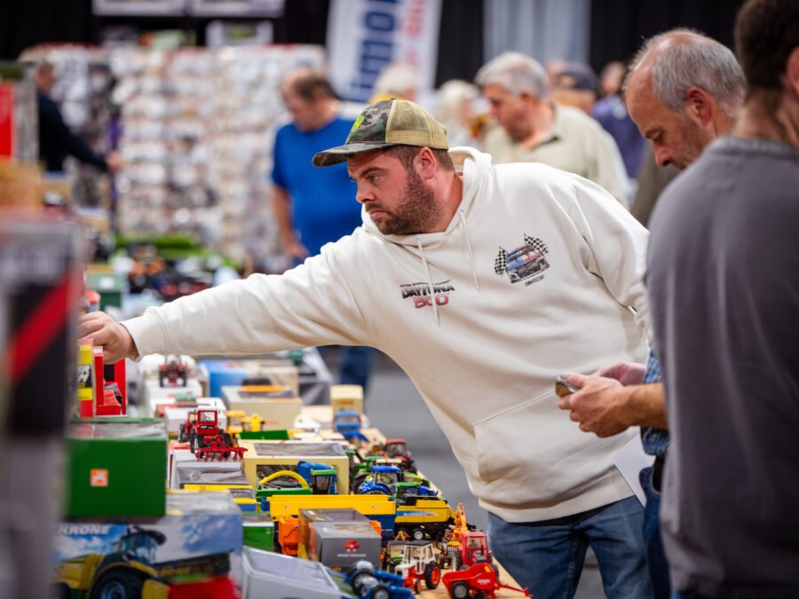 Trader reaching across a table of boxed farm and construction models at the Spalding Model Tractor Show