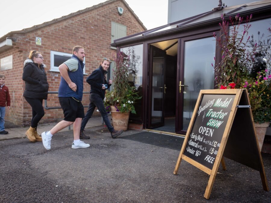 Visitors arriving at the Spalding Model Tractor Show past the chalkboard entrance sign