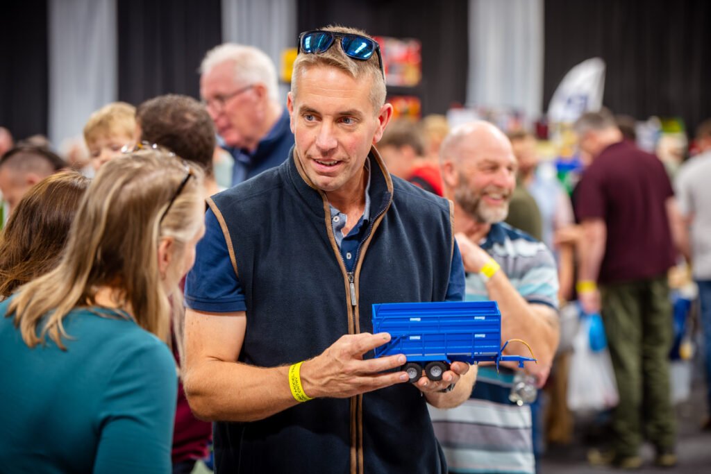 An exhibitor showing a boxed model to visitors