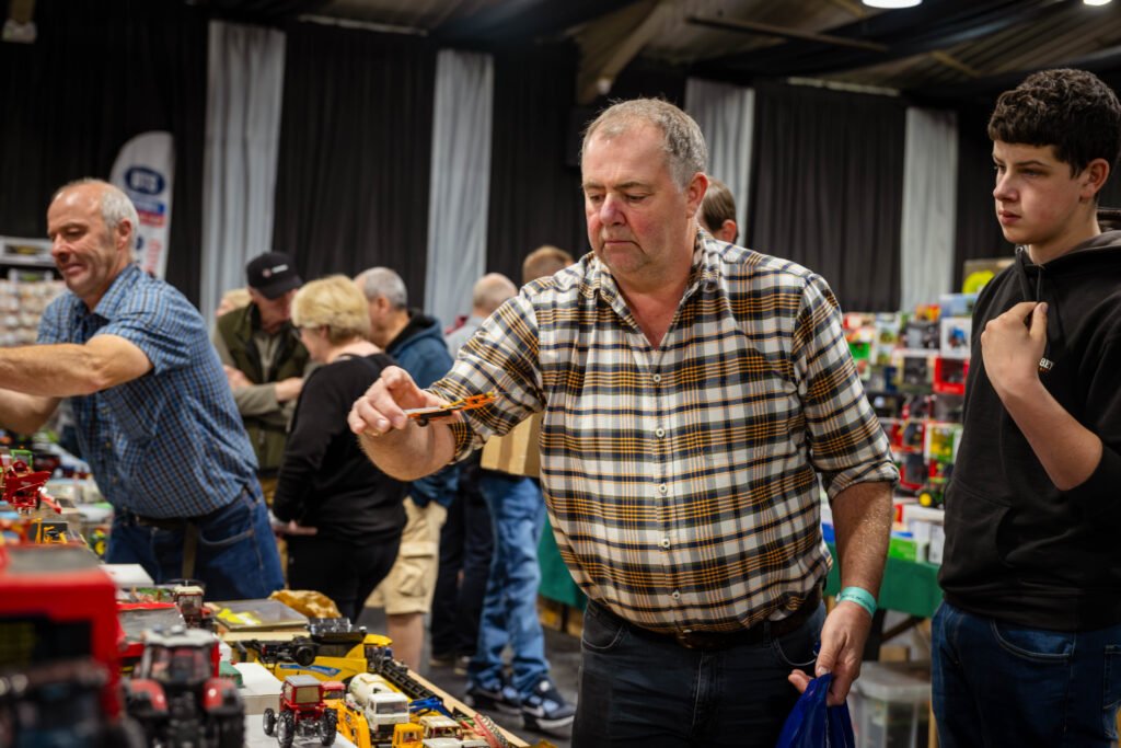 Visitor examining a model tractor at a trade stand, Spalding Model Tractor Show