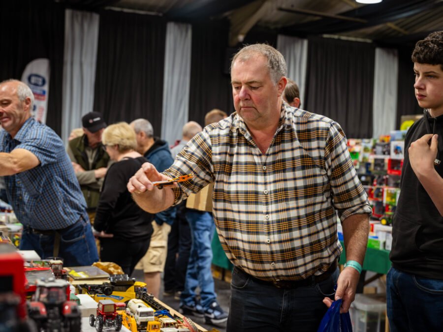 Visitor examining a model tractor at a trade stand, Spalding Model Tractor Show