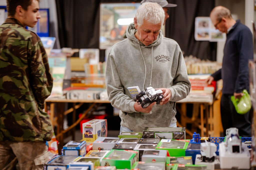 A visitor inspecting a model lorry at a trade stand