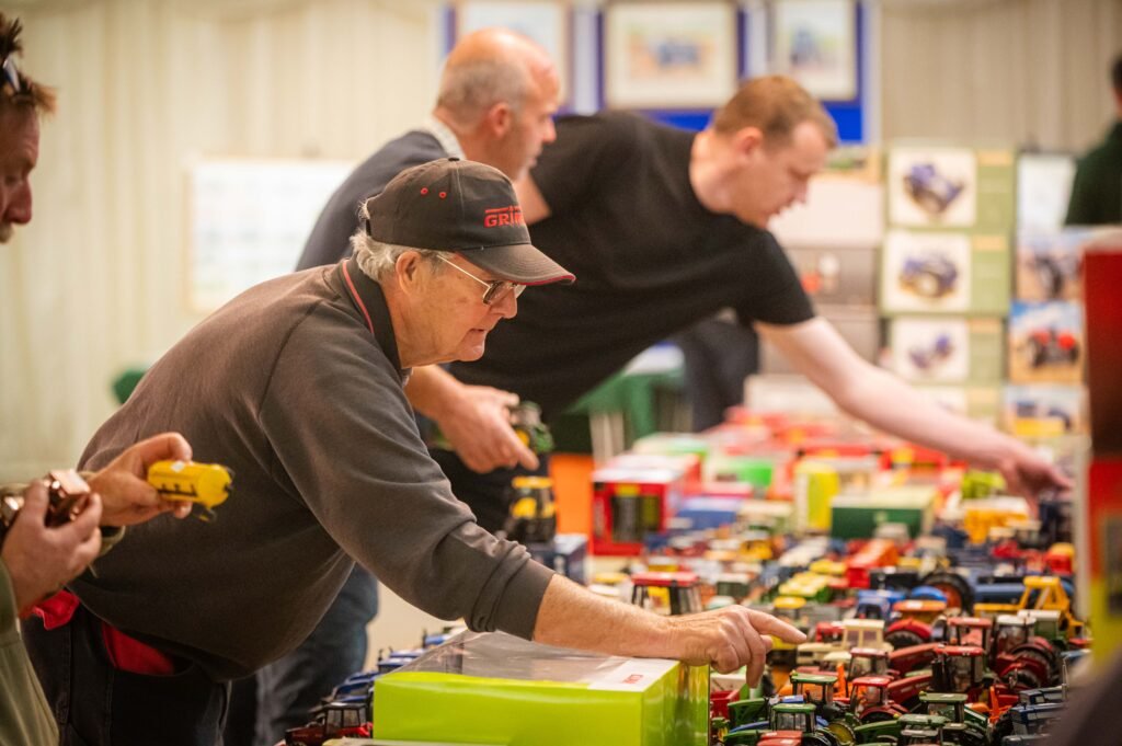 A trader arranging model tractors on his table
